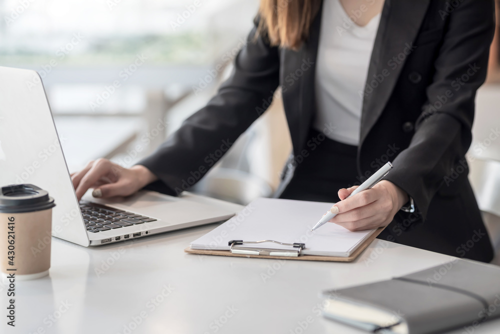 Young business woman take notes and using a laptop in the office. Young business woman take notes and using a laptop in the office.
