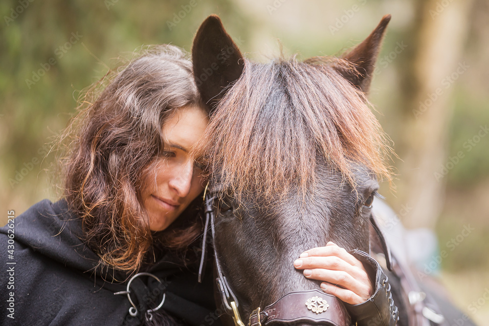 Fototapeta premium woman in historical costume as a warrior hugs his horse