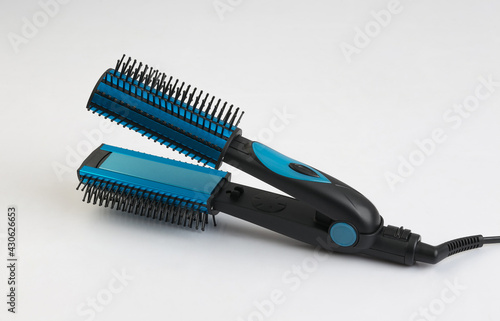 Blue hair straightener with comb isolated on white background