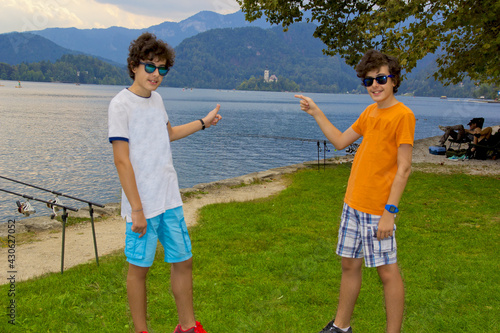 happy twins in sunglasses in lake bled, slovenia