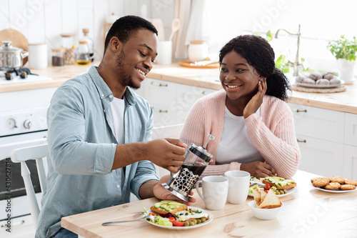 Domestic Leisure. Millennial Black Couple Sitting At Table  Having Breakfast In Kitchen