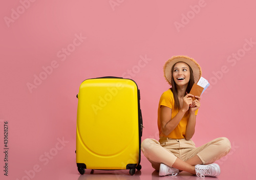 Surprised young woman traveler holding passport, lloking at copy space photo