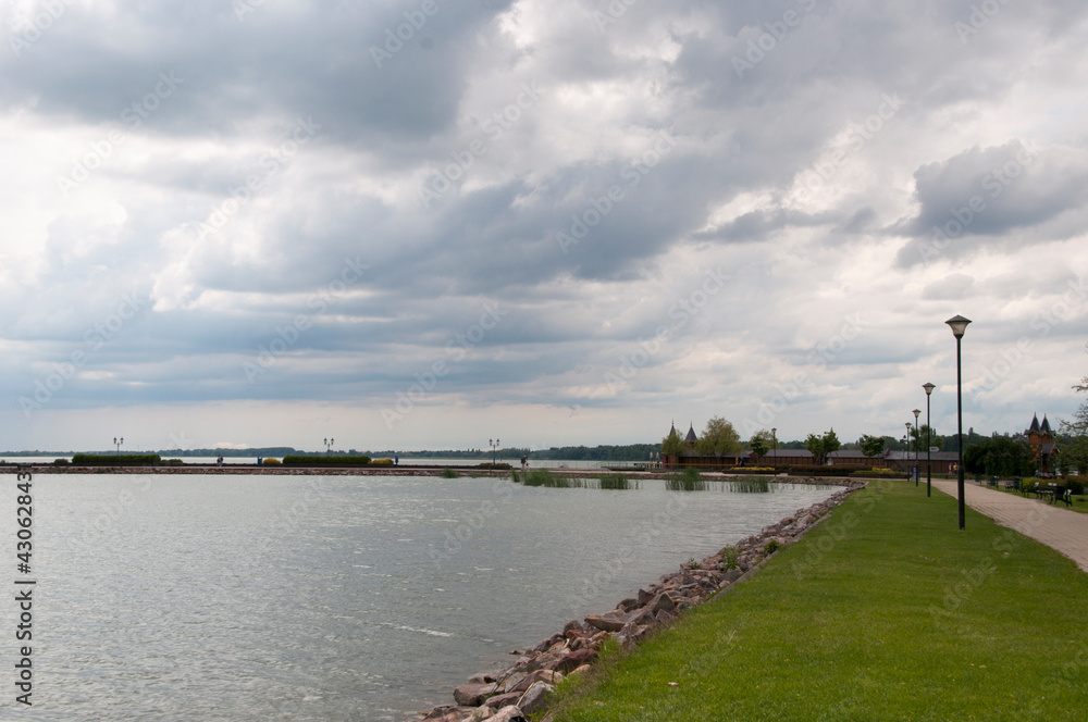Panoramic view of the embankment with green lawns and the calm surface of Lake Balaton.