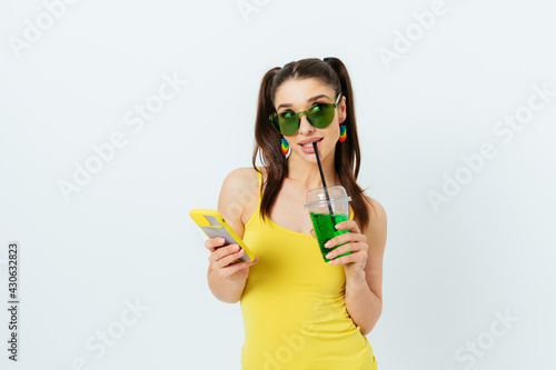Beautiful cunning young woman wearing yellow summer top and green sunglasses