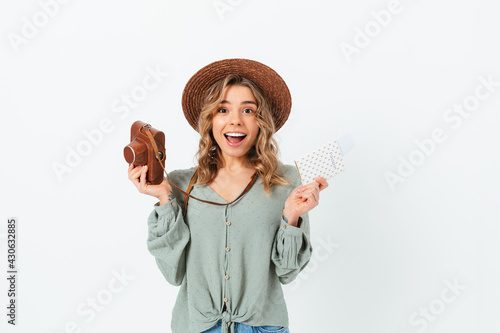 Joyful excited young woman holding photo camera and passport