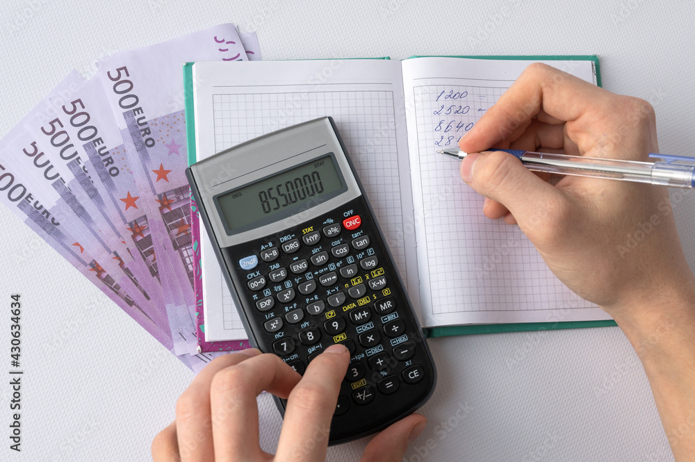 Men's hands with pen, notepad, calculator and money on white background. Home Finance Men's hands with pen, notepad, calculator and money on white background. Home Finance