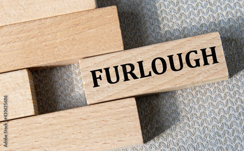 FURLOUGH- word on a wooden bar on a gray background