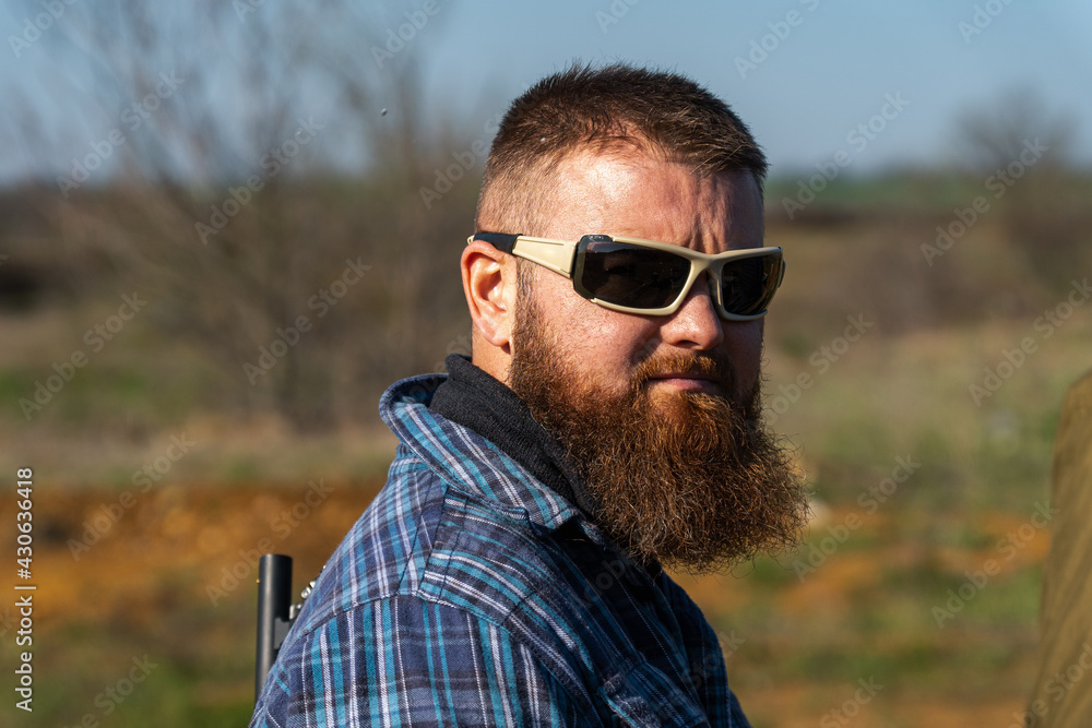 Bearded man in glasses with plaid shirt look at the camera, soft focus Bearded man in glasses with plaid shirt look at the camera, soft focus