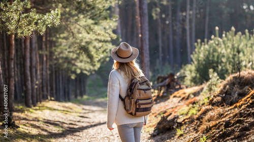 Valokuva Woman with hat and backpack hiking in woodland