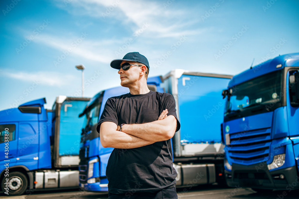 Professional truck driver with hat and sunglasses confidently standing