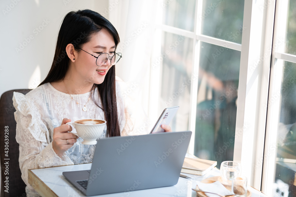 Happy of asian freelance people Businesswoman writing message on smartphone and hold a coffee cup mug casual working with laptop computer at the cafe,Business Lifestyle Happy of asian freelance people Businesswoman writing message on smartphone and hold a coffee cup mug casual working with laptop computer at the cafe,Business Lifestyle