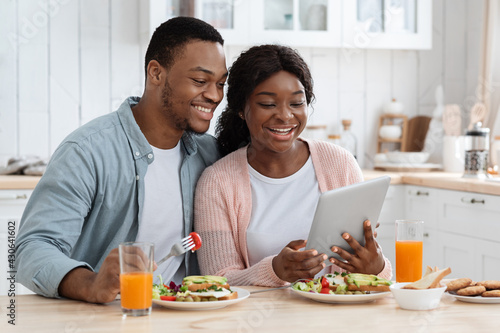 Online Shopping. Millennial Black Couple In Kitchen Using Digital Tablet During Breakfast