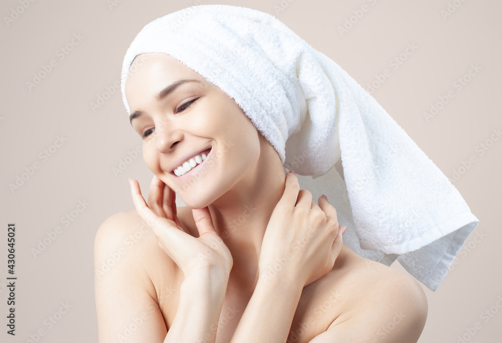 Cute positive girl in towel on her hair on beige background Cute positive girl in towel on her hair on beige background