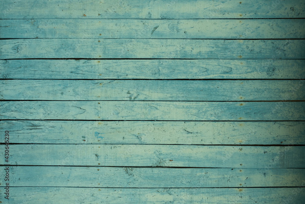 Background of an old wooden fence in turquoise or green. Pastel delicate shade. The texture of the painted old wood Background of an old wooden fence in turquoise or green. Pastel delicate shade. The texture of the painted old wood