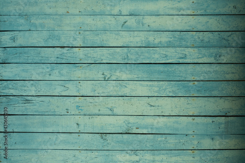 Background of an old wooden fence in turquoise or green. Pastel delicate shade. The texture of the painted old wood