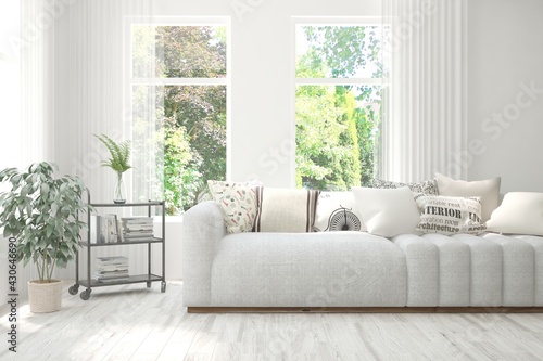 Minimalist living room in white color with sofa and summer landscape in window. Scandinavian interior design. 3D illustration © AntonSh