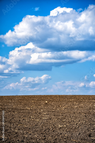plowed field against the sky with clouds