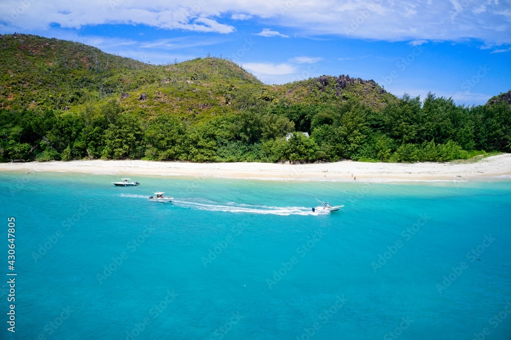 Drone field of view of speeding boat in turquoise water Curieuse Island, Seychelles.