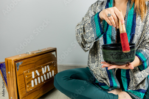 Woman playing a Tibetan singing bowl, music therapy. Woman performing kirtan, chanting mantras. photo