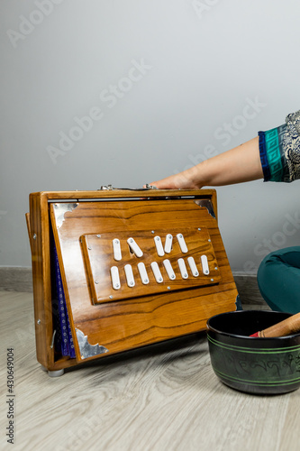 Shruti, a musical instrument of Indian origin. Indian harmonium. Woman performing kirtan, chanting mantras. photo