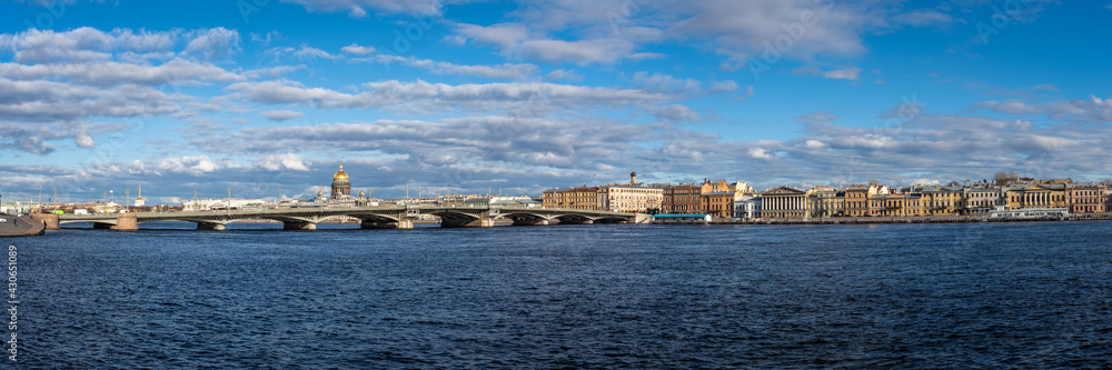 Amazing Panorama of St. Petersburg, Russia. River Neva granite embankment. Sunny spring day. On the horizon are famous historical buildings on white clouds background. View from 