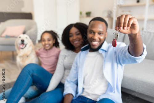 Happy black family showing keys of their new apartment