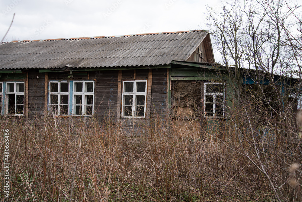 An old abandoned house overgrown with bushes. The concept of abandonment and uselessness An old abandoned house overgrown with bushes. The concept of abandonment and uselessness