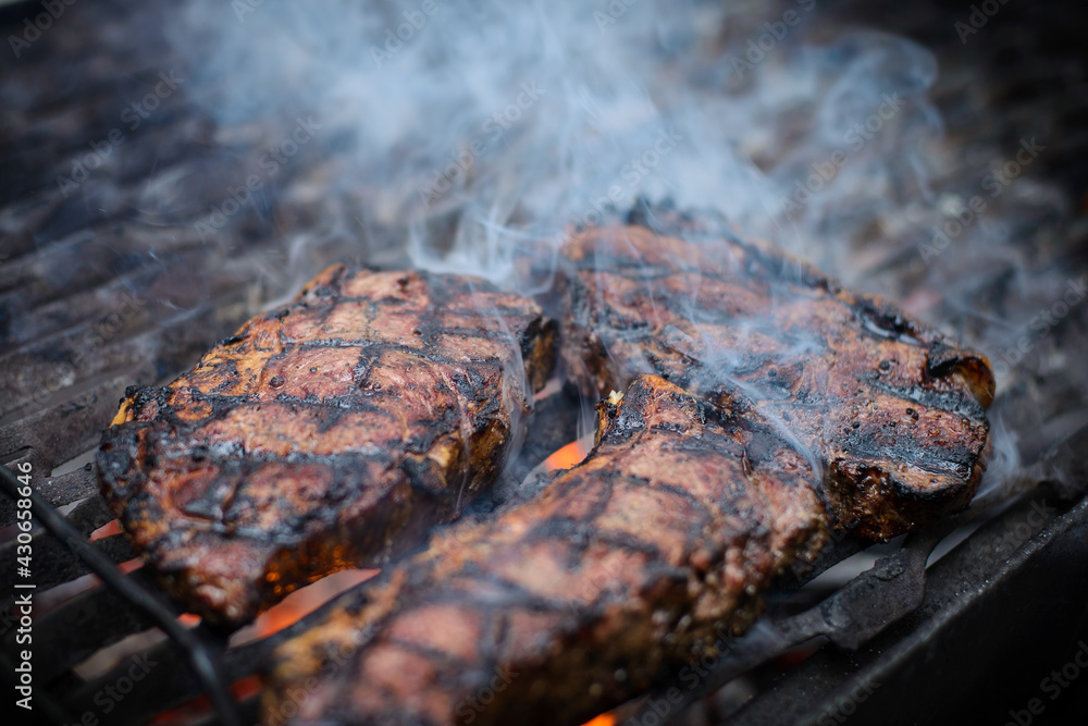 Steak on grill with steam, juice and cross pattern burned in. Steak on grill with steam, juice and cross pattern burned in.