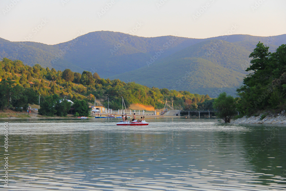 Summer landscape with a lake in the mountains - in the evening haze and setting sun after a hot June day. Summer landscape with a lake in the mountains - in the evening haze and setting sun after a hot June day.