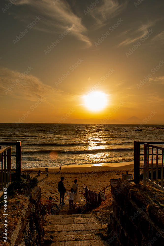 葉山の海の夕景　夕日が沈む浜辺で遊ぶファミリー　神奈川県立葉山公園　大浜海岸