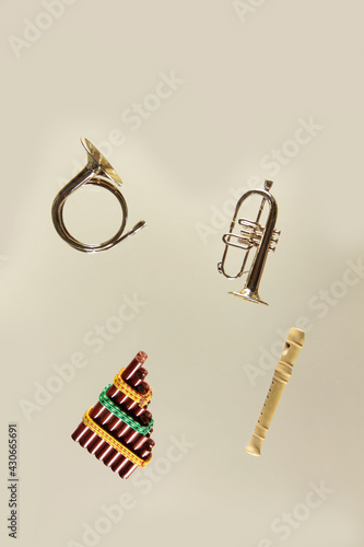 wind musical instruments - pan flute, blockflute, pipe and hunting horn on light background