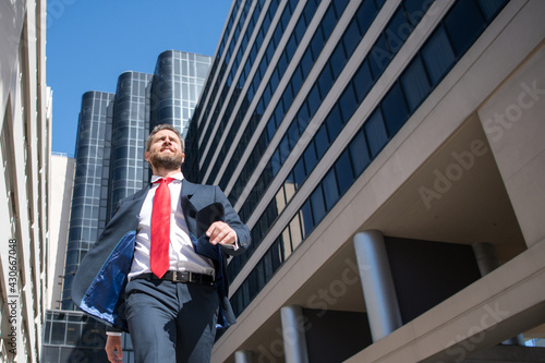 Businessman walking on the street. Business man walk near modern business center. Business and architecture concept.