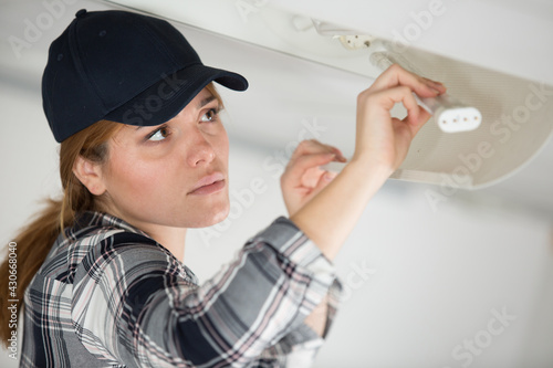 female contractor replacing a fluorescent bulb