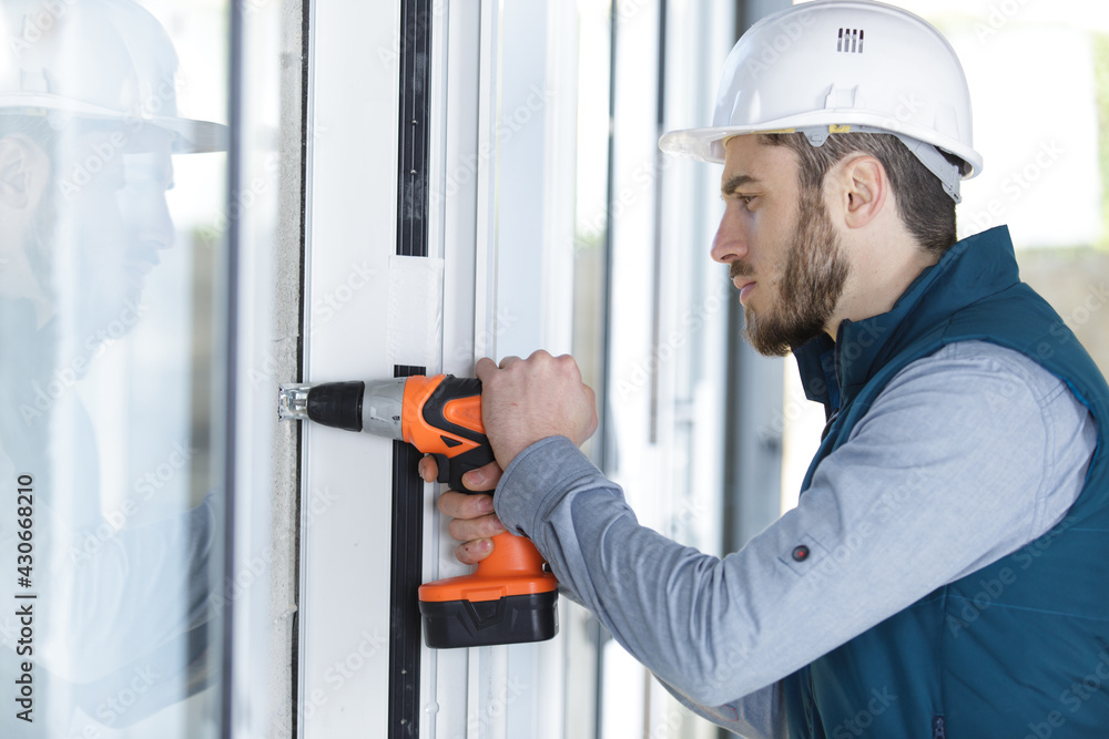 man installing window shades at home