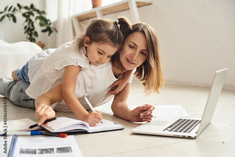 mom works at the computer while playing with her daughter mom works at the computer while playing with her daughter