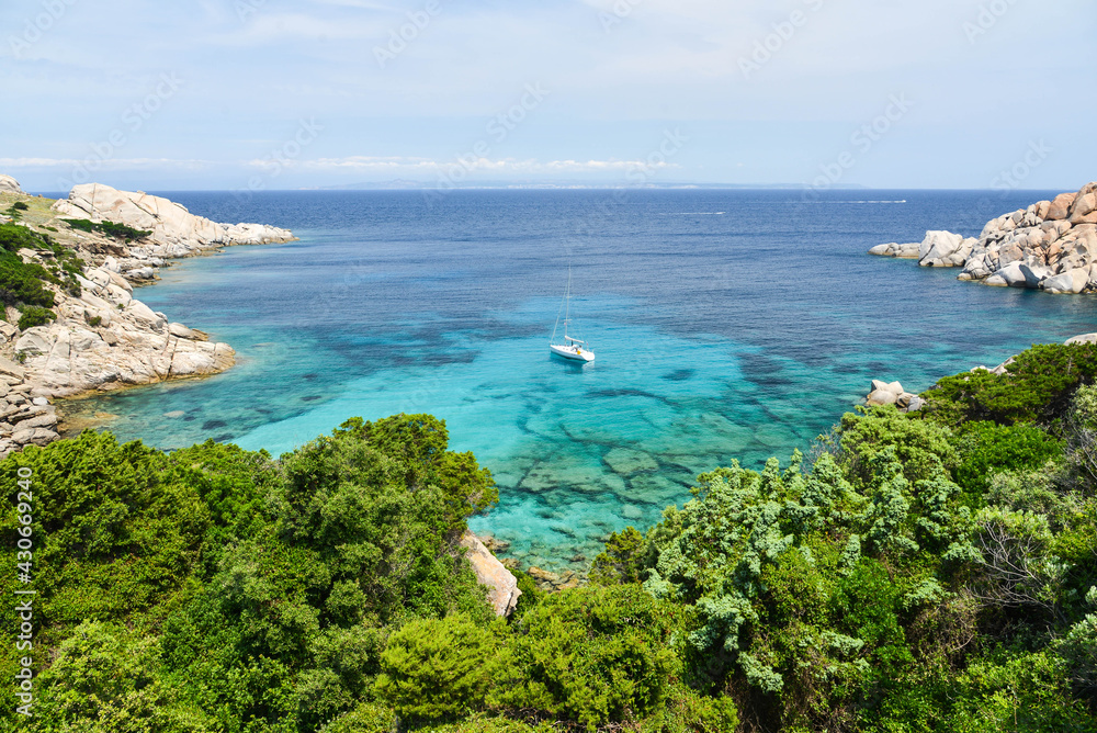 Blaue Bucht mit Segelboot bei Capo Testa auf Sardinien am Mittelmeer mit Blick auf Korsika