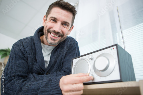 Obraz na plátně man adjusting volume on his home sound system