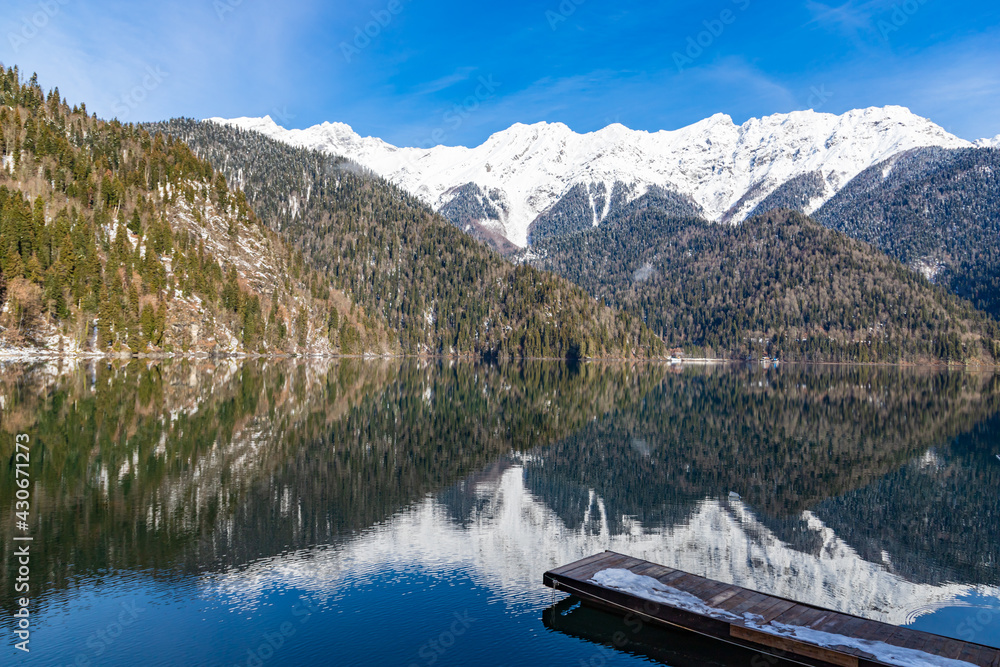 Mountain glacial lake Ritsa in Abkhazia at winter season. Rocky mountain peaks covered with snow. Mountain landscape. Abkhazia.