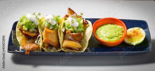 pork belly tacos served with guacamole