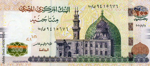A fragment of the obverse side of 200 Egyptian pounds banknote, obverse side has an image of Mosque of Qani-Bay Cairo, Egypt. The reverse side has an image of The Seated Scribe photo