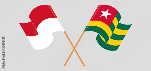 Crossed and waving flags of Indonesia and Togo