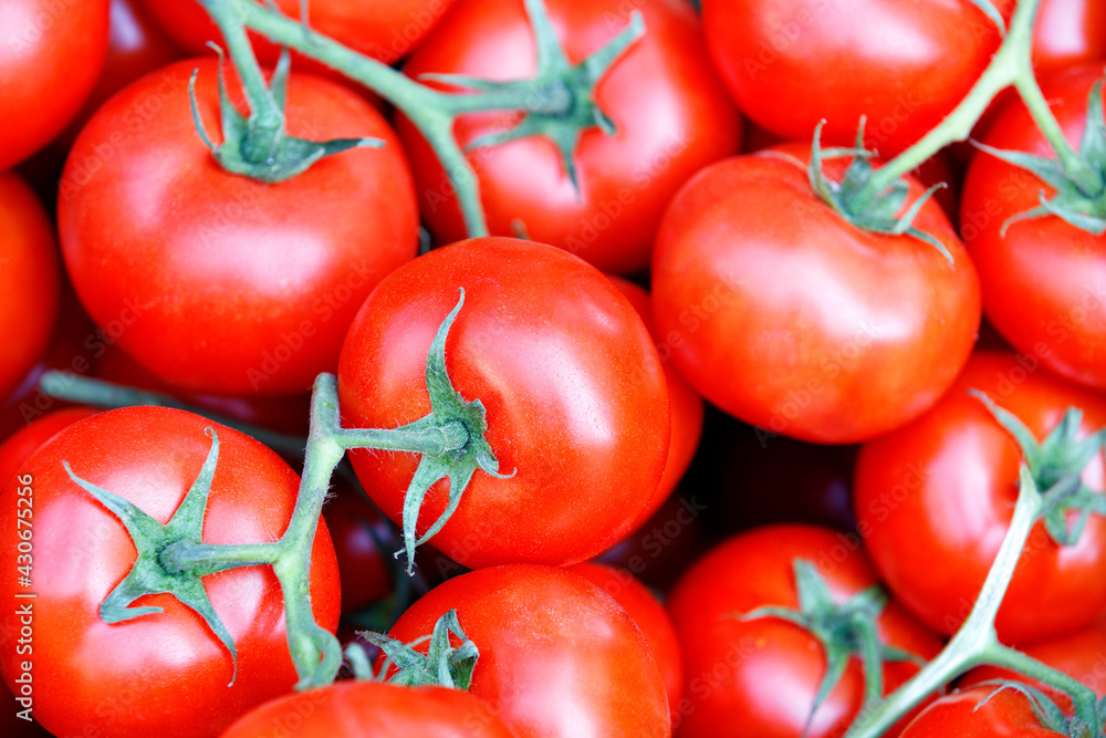 Branches of fresh red tomatoes with green stems close-up. Branches of fresh red tomatoes with green stems close-up.
