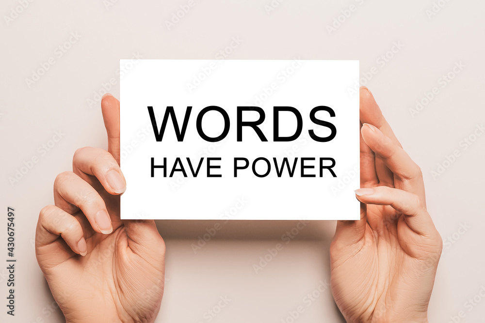 Female hands hold card paper with text Words Have Power on a yellow background. Business and finance concept Female hands hold card paper with text Words Have Power on a yellow background. Business and finance concept