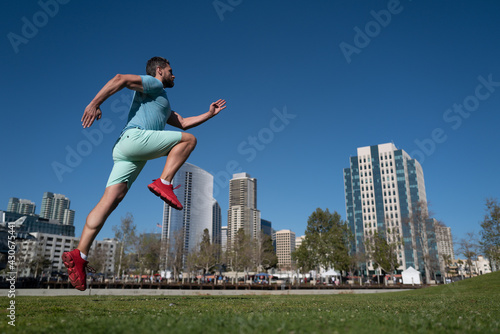 Man running outdoors on the town. Jogging in a city park.