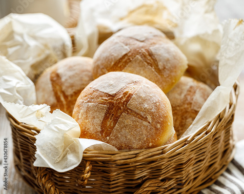 Homemade wheat rolls freshly baked in a wicker basket, close up view. Homemade breakfast