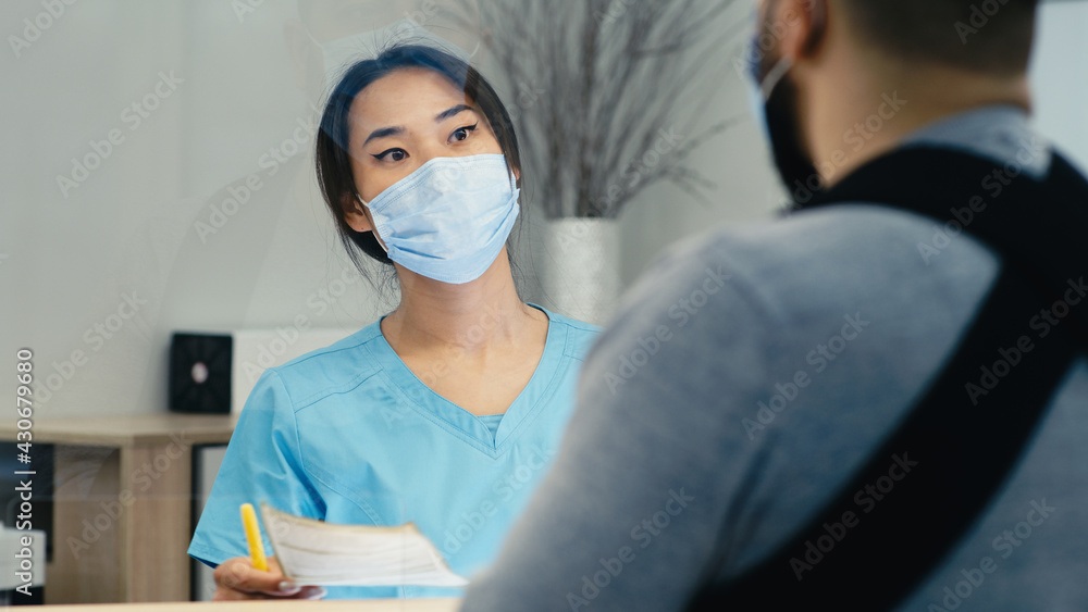 Asian receptionist showing direction to injured man