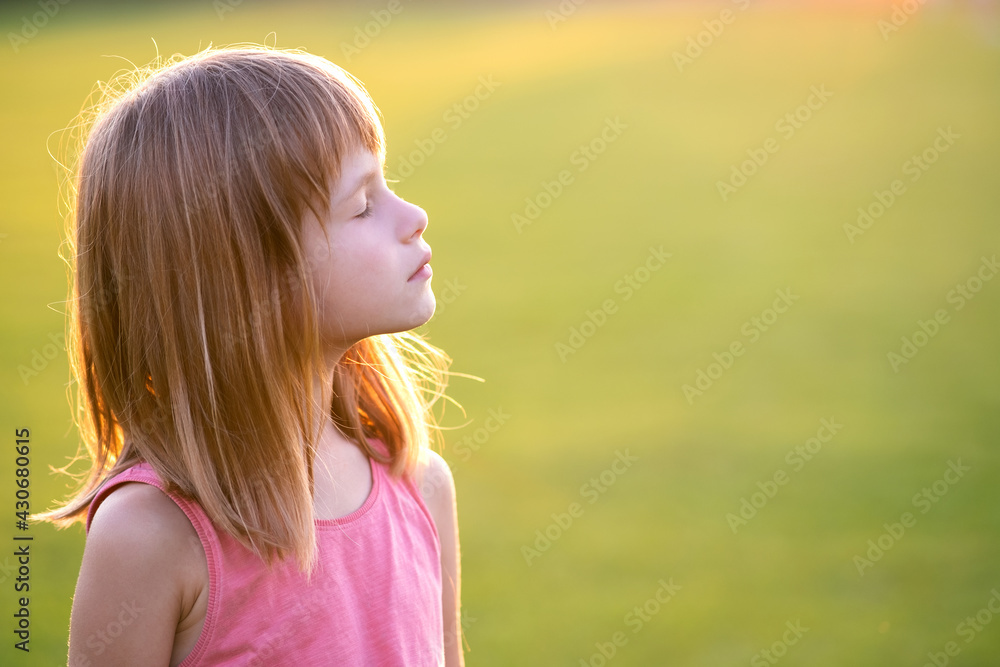 Portrait of young happy child girl relaxing outdoors on warm summer evening. Portrait of young happy child girl relaxing outdoors on warm summer evening.