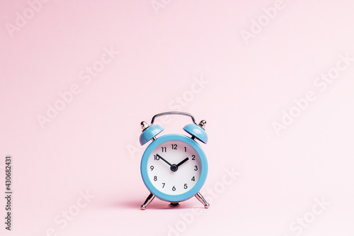 blue alarm clock over pink background. outer space. minimal. time planning concept