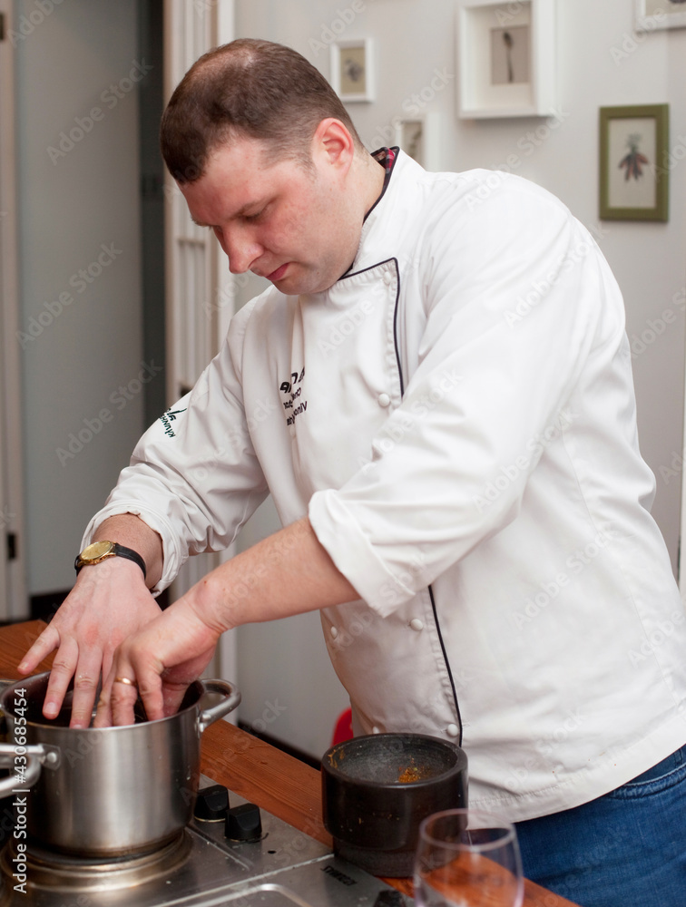 Food and people concept: male chef with cooked food standing in the kitchen. Food and people concept: male chef with cooked food standing in the kitchen.