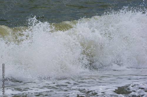 sea landscape is a pebbly beach with waves in white foam